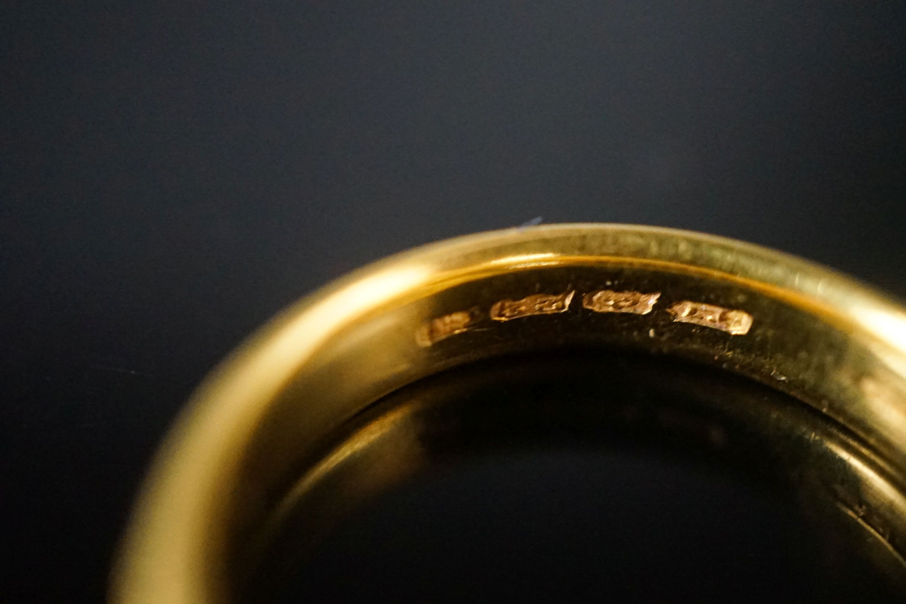 A George V bright cut engraved 22ct gold wedding band, decorate with flower heads, London, 1918, size V, 8 grams.